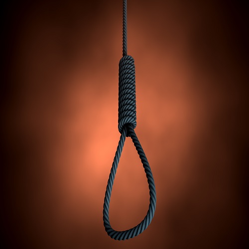An eerie silhouetted view of a rope made into a hangmans noose on an orange backlit background