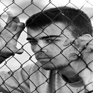 Teenager behind a wired fence. Black and white photo